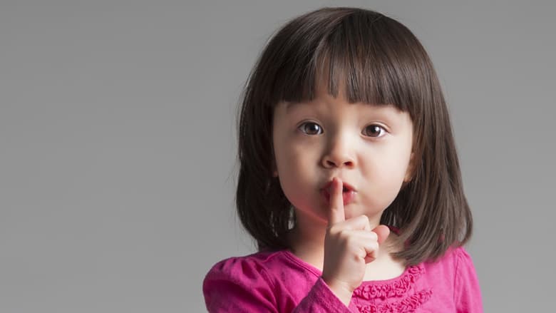 Young girl motioning to 'be quiet'