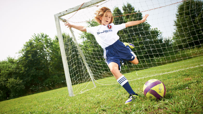Growth for Sports Medicine Tween girl playing soccer in front of net