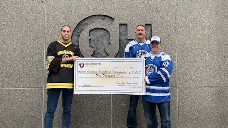 Team members holding a large check