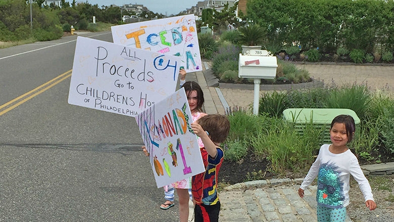 Children holding lemonade signs