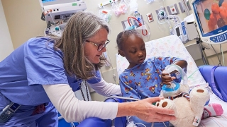 Member of anesthesia team with child prior to surgery