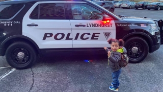 Asher standing next to a cop car