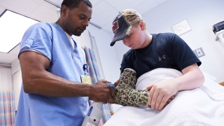 Clinician with boy in arm cast