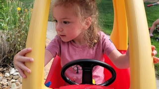 Amelia having fun in a toy car