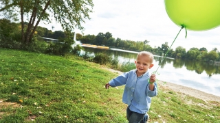 Tommy playing with a baloon at a park