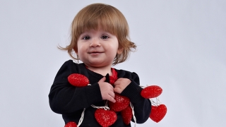 zoey holding hearts on string