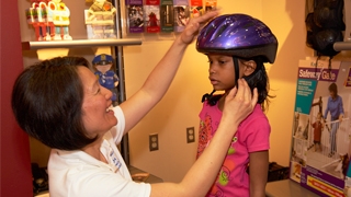 child trying on biking helmet