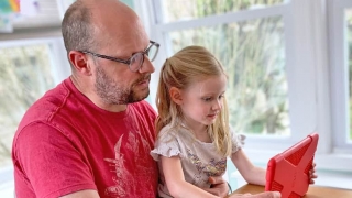 Father and daughter sharing tablet screen
