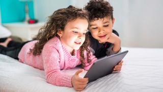 Two children using a mobile tablet