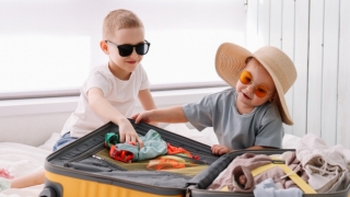 Two kids packing a suitcase