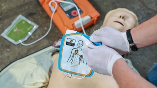 Hands setting up a defibrillator