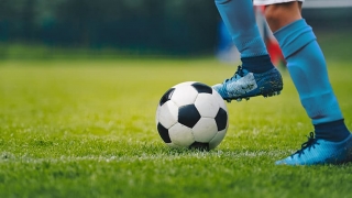 Closeup of soccer player's cleats and soccer ball
