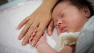 Infant holding onto finger