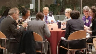 Medical professionals sitting around table having dinner at conference