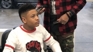 Teen patient getting hair cut in barbershop