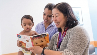 doctor and mother reading to infant