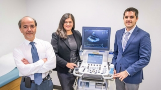 Three doctors standing with ultrasound machine