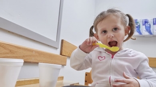 Young girl eating with a spoon