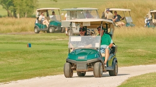 Golfers riding in golf carts