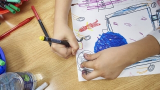 Child's hand coloring a picture