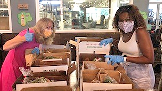 Two employees packing produce boxes