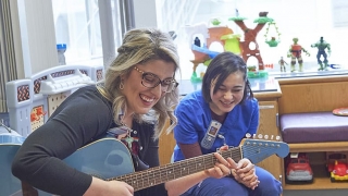 CHOP music therapist playing guitar