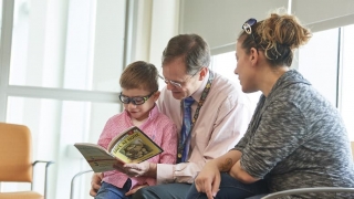Young onco patient being read a book