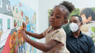 Little girl looking at the mural art