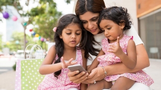 Mom with two daughters shopping on smart phone