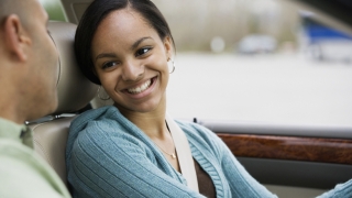 Teen girl driver in car smiling at father