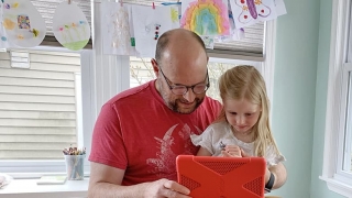 Father with daughter on mobile tablet