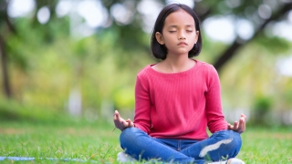 Young girl meditating outside