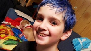 Zak with blue hair smiling