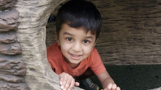 Zaki playing in a fake rock cave
