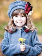 portrait young girl outside smiling holding flowers in coat