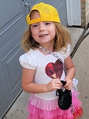 Amelia smiling wearing a yellow hat