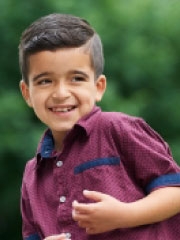 boy in red shirt outside smiling