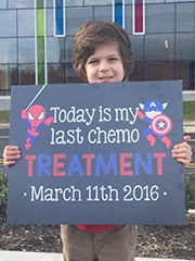 Max holding a sign signifying the end of his treatment