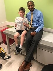 Max shows Dr. Sankar one of the 70 care packages he and his family put together for other patients being treated for Legg-Calve-Perthes disease at CHOP.