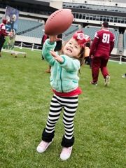 Young girl catching a football