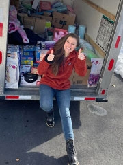 Emily sitting in truck of donated items