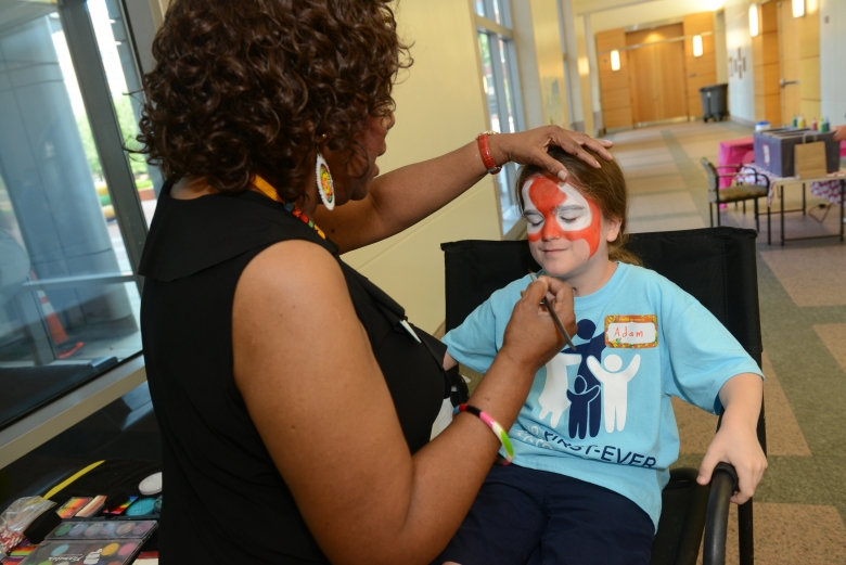 Female patient getting face painted at hospital event