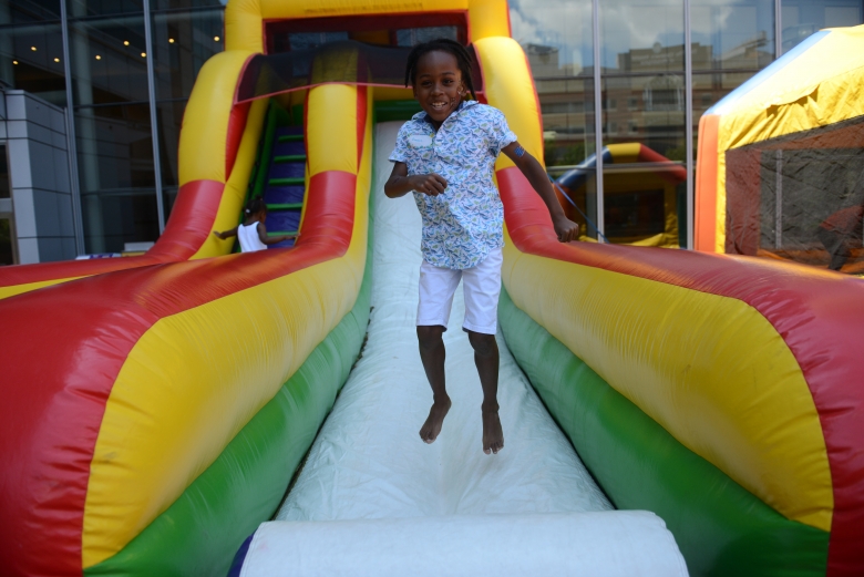 Girl at hospital event jumping in inflatable slide
