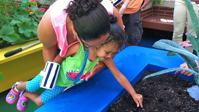 Child touching soil in Sea Garden