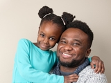 Father hugging his daughter and smiling