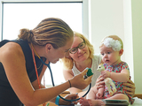 Doctor showing stethoscope to baby girl