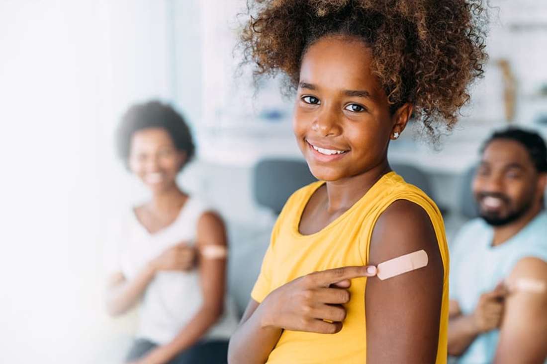 Teen pointing to arm after getting a shot.