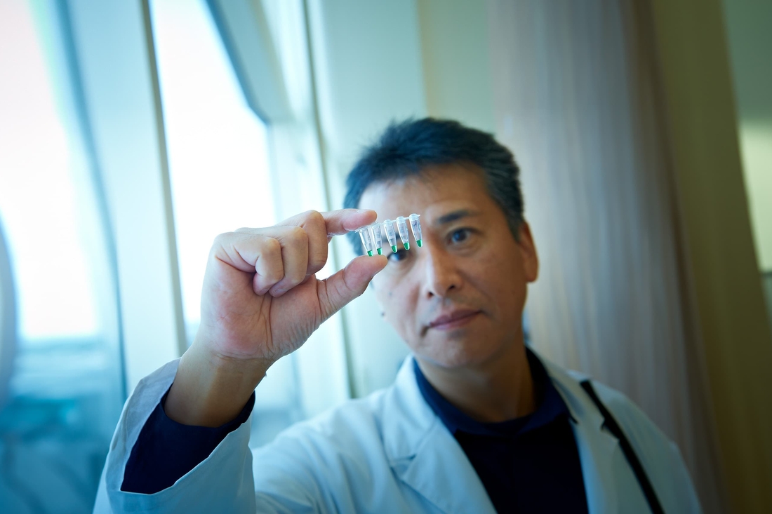 Researcher viewing a sample in a vial