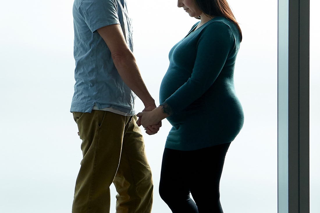 Pregnant couple photographed in silhouette