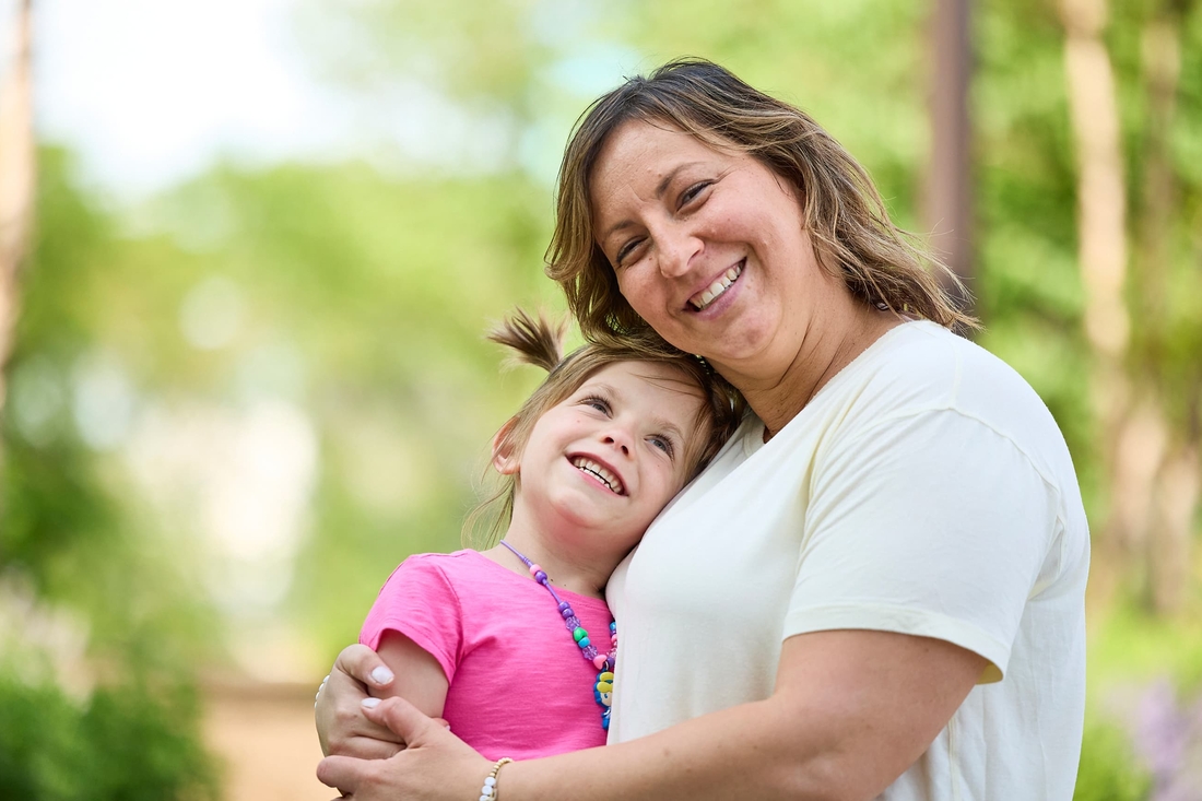 Girl with pink dress and her mom hugging in the hospital garden